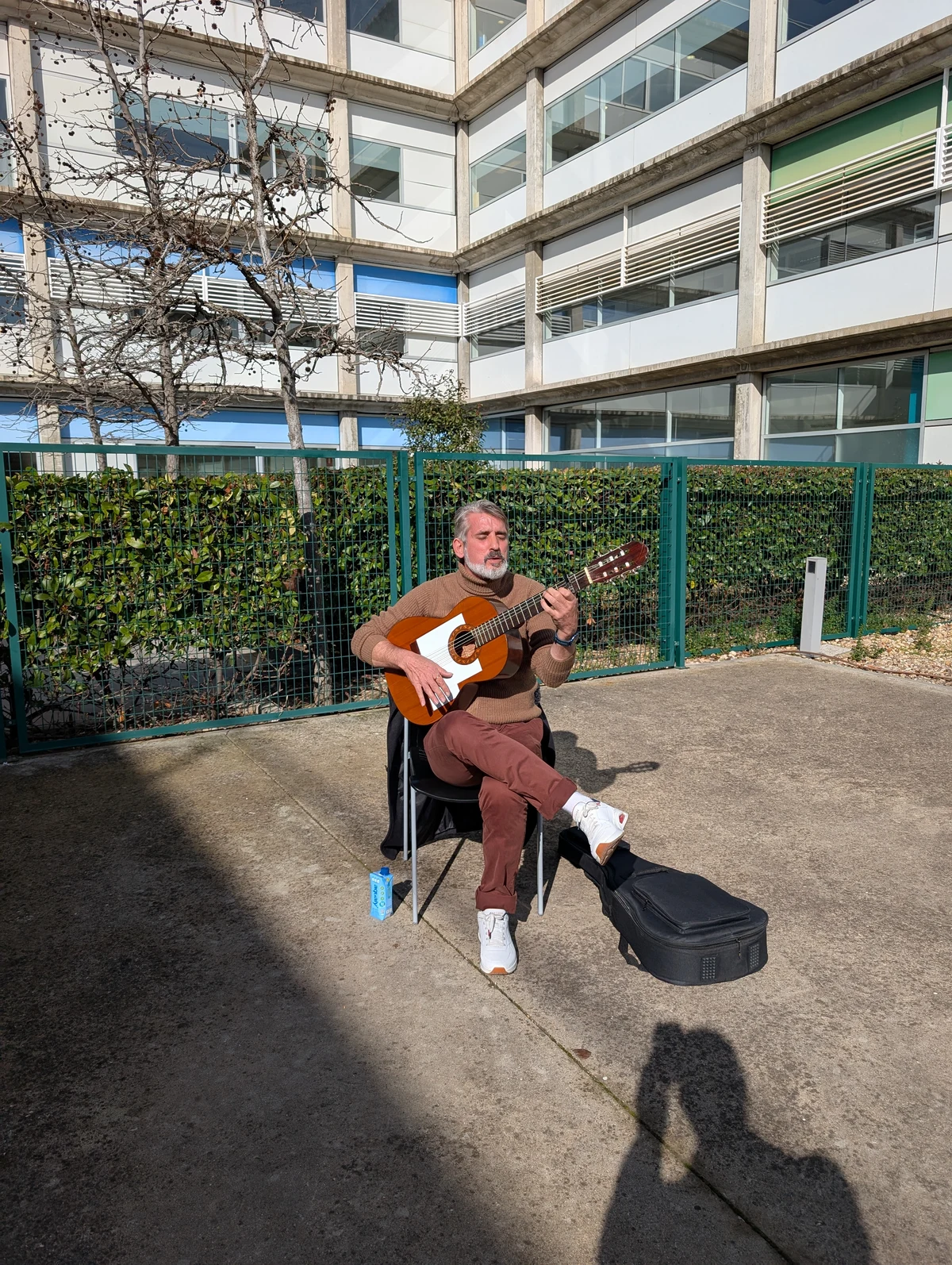 Tito tocando la guitarra al aire libre durante un descanso de las jornadas de 2025
